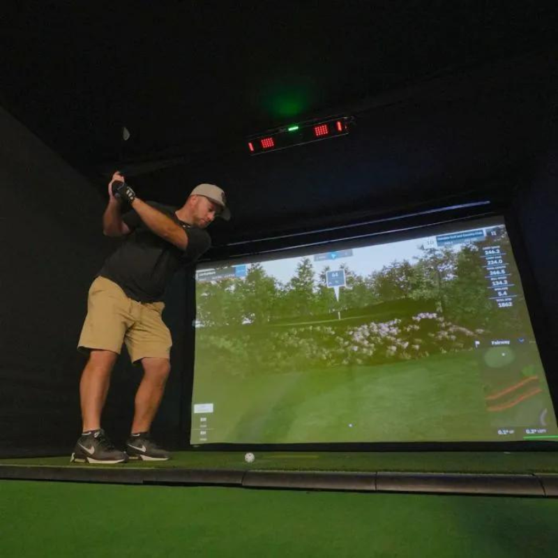 Carl's Place Uneekor EYE XO2 Protective Case installed in golf simulator with golfer swinging.