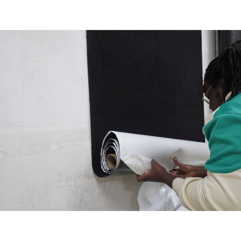 Impact Sports Felt Wall Covering Roll being pressed onto a wall as the release liner is pulled away.