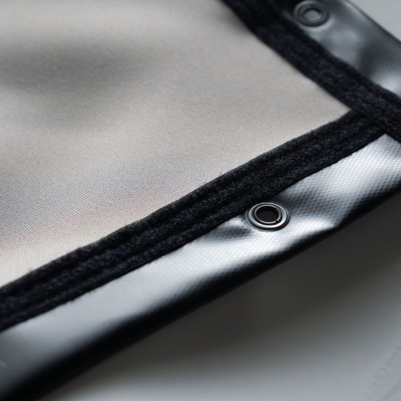 SIGPRO Premier Golf Simulator Impact Screen featuring a closeup of the screen fabric corner with reinforced black edge and grommet.