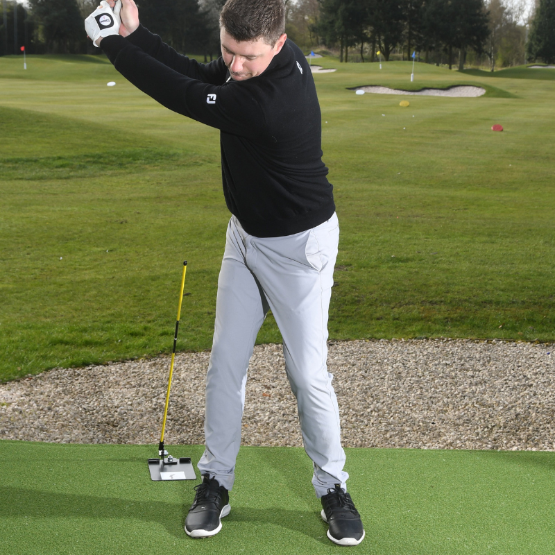The Swing Plate Base with golfer at top of backswing caddie view.