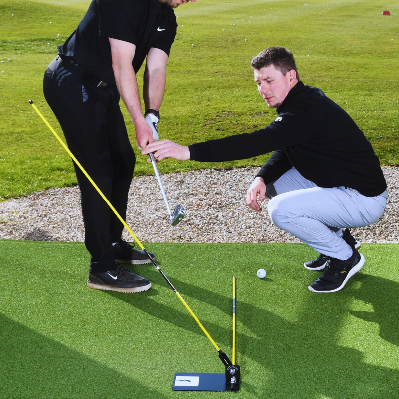 The Swing Plate Base down the line view with golfer and instructor.